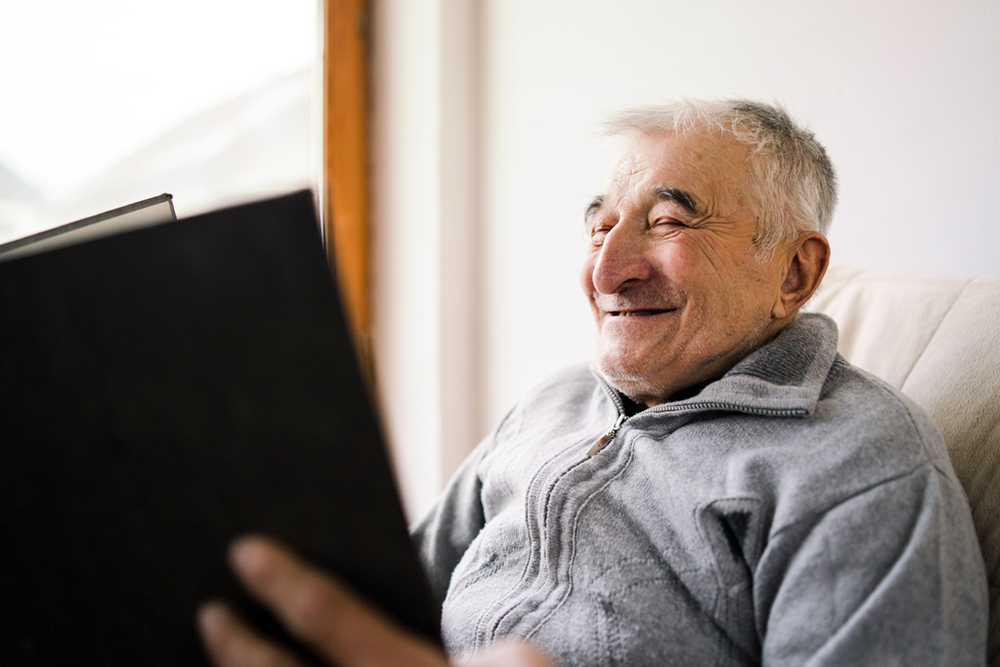 Senior old man watching looking a book family album photos